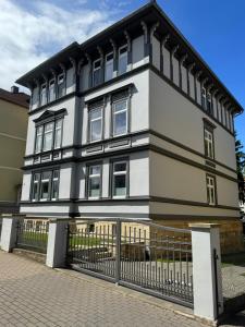 a white and black house with a fence at Apartment Stadtperle in Gotha