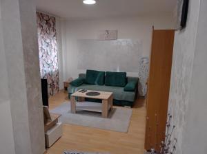 a living room with a green couch and a table at CaSa BOULEVARD in Brčko