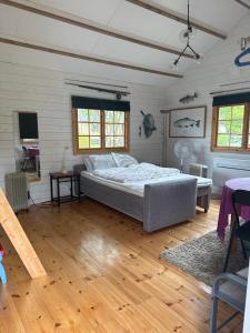 a bedroom with a bed in a room with wooden floors at Sportfiskestugan in Färjestaden