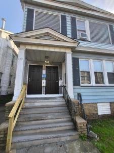 a blue house with a black door and stairs at Log Comfort 3 in Irvington
