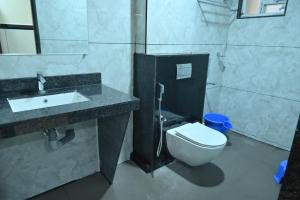 a bathroom with a white toilet and a sink at Kamath Yatri Nivas Plus in Māvalli