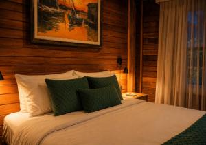 a bedroom with a bed with green and white pillows at Kastel Pedra Bonita in Petrópolis