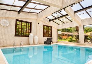 a swimming pool in a house with windows and a swimming pool at Kastel Pedra Bonita in Petrópolis +42 photos