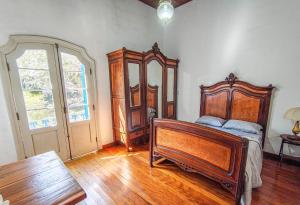 a bedroom with a wooden bed and a wooden dresser at Refúgio Casarão in Passa Quatro
