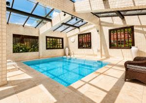 a swimming pool in a house with a glass ceiling at Kastel Pedra Bonita in Petrópolis