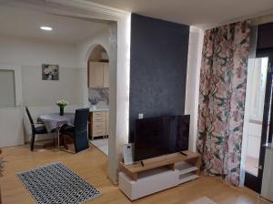 a living room with a television and a dining table at CaSa BOULEVARD in Brčko
