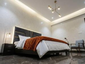 a bedroom with a large bed and a chair at Hotel Brothers Kalka Highway in Panchkula