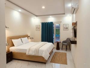 a bedroom with a bed and a desk and a window at Hotel Brothers Kalka Highway in Panchkula