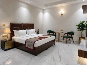 a bedroom with a bed and a table and chairs at Hotel Brothers Kalka Highway in Panchkula