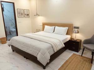 a bedroom with a large bed and a chair at Hotel Brothers Kalka Highway in Panchkula