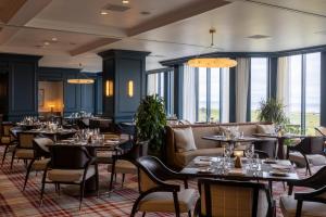 a restaurant with tables and chairs and windows at Old Course Hotel St Andrews in St. Andrews