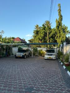 a parking lot with two cars parked in it at Luxe cozy home in Dar es Salaam