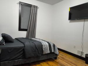 a bedroom with a bed and a flat screen tv at Log Comfort 3 in Irvington