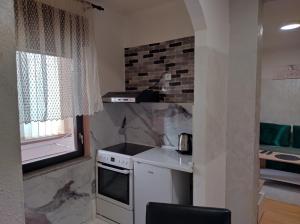 a small kitchen with a stove and a window at CaSa BOULEVARD in Brčko