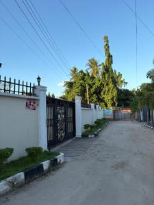 an empty street with a fence and a driveway at Luxe cozy home in Dar es Salaam