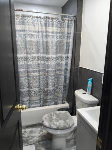 a bathroom with a toilet and a shower curtain at Log Comfort 3 in Irvington +6 photos