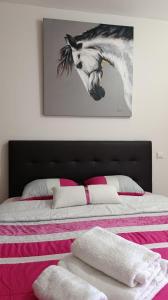 a bedroom with a bed with a picture of a horse at Flamant apart in Aguçadoura