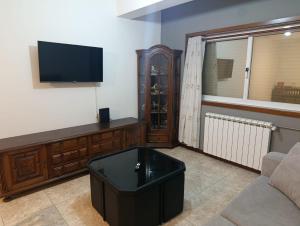 a living room with a tv and a couch at Flamant apart in Aguçadoura