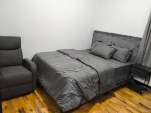 a bed and a chair in a room with a bed and a couch at Log Comfort 3 in Irvington