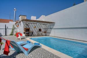 a swimming pool with chairs next to a building at Morada da Vovó Alda in Almeirim +58 photos