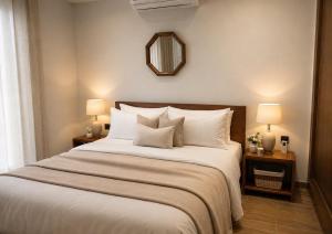 a bedroom with a large bed with white pillows and a mirror at Azra Luxe villa famille uniquement Family only in Saïdia +3 photos