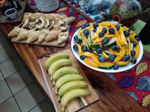 a table topped with bananas and blueberries and other foods at Airport Bird & Game Lodge in Kempton Park