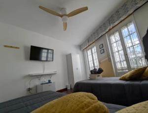 a bedroom with two beds and a ceiling fan at Casa Magua Melide in Melide