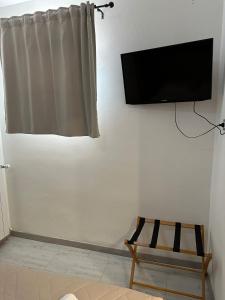 a flat screen tv hanging on a wall with a chair at Sole e Luna in Lonato
