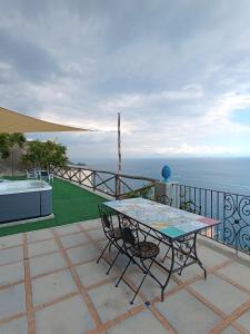 a table and chairs on a balcony with the ocean at Villa Gea in Praiano