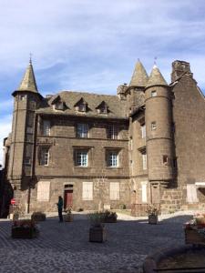 a large castle with a person standing in front of it at Chalet en Auvergne -Pêche in Roumégoux