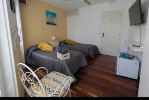 a room with two beds and a table and chairs at Casa Magua Melide in Melide