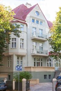 un gran edificio blanco con techo rojo en Pensjonat Eden en Sopot