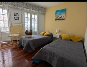 two beds in a room with two windows at Casa Magua Melide in Melide