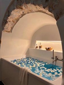 a bathroom with a bath tub filled with water at La Suite di Alizeh in Ostuni +16 photos