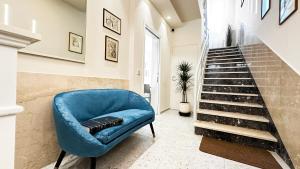 a blue chair in a hallway with a staircase at R&B Dimora Teodorico in Ravenna +40 photos