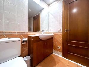 a bathroom with a toilet and a sink and a door at AC Apartaments Comapedrosa Canillo in Canillo +6 photos