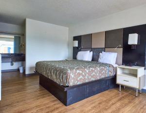 a bedroom with a large bed and a night stand at Magnuson Hotel Jacksonville Downtown in Jacksonville +17 photos