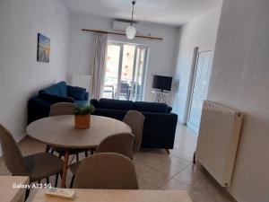 a living room with a blue couch and a table at Menidi Apartment 101 in Menídion