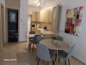 a kitchen and dining room with two tables and chairs at Menidi Apartment 101 in Menídion