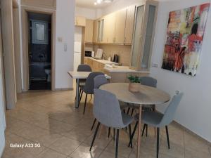 a kitchen and dining room with two tables and chairs at Menidi Apartment 101 in Menídion +6 photos