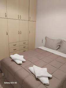 a bedroom with a bed with white cabinets and white towels at Menidi Apartment 101 in Menídion