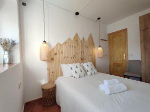a bedroom with a large white bed with two pillows at El cielo de Béjar, casa rural in Béjar