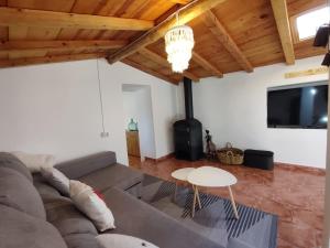 a living room with a couch and a tv at El cielo de Béjar, casa rural in Béjar