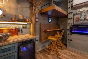a kitchen with a stove and a wooden stool at "Squirrels Gone Wild" Luxury Treehouse Adventure Near Dollywood & Pigeon Forge in Sevierville