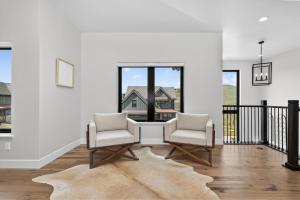 two chairs and a table in a room with windows at 238 Night Hawk Home in Granby +28 photos