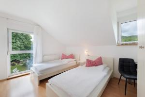 a white room with a bed and a window at Ferienwohnungen Knodel in Sachsenheim +99 photos
