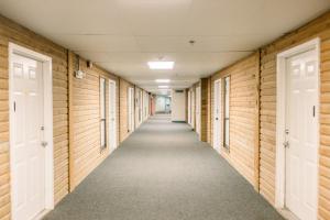 a hallway of a building with wooden walls and doors at Blue Pearl Beachfront Condo at Casa de Mar in Galveston