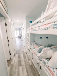 a bedroom with two bunk beds and a hallway at Blue Pearl Beachfront Condo at Casa de Mar in Galveston