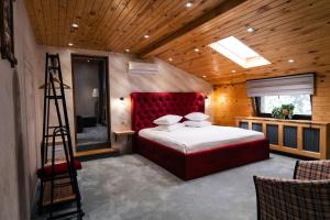 a bedroom with a large red bed and a ladder at Casa Seciu in Ploieşti