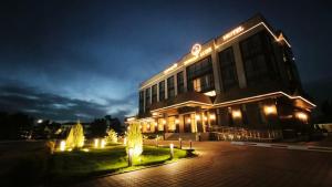 a building with lights in front of it at night at NOMAD Luxe Hotel in Zharkent